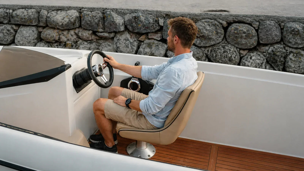 Boat operator seated at the helm while checking seat position and control reach