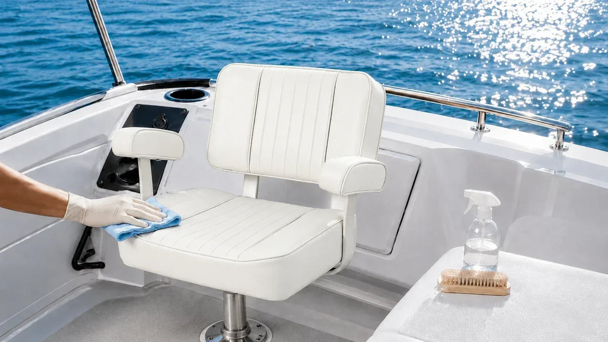 Gloved hand cleaning a white marine boat seat with a microfiber cloth in a sunlit boat cockpit.