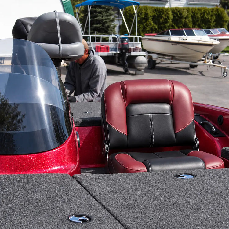Red and black bass boat seat installed beside the console on a red fishing boat.