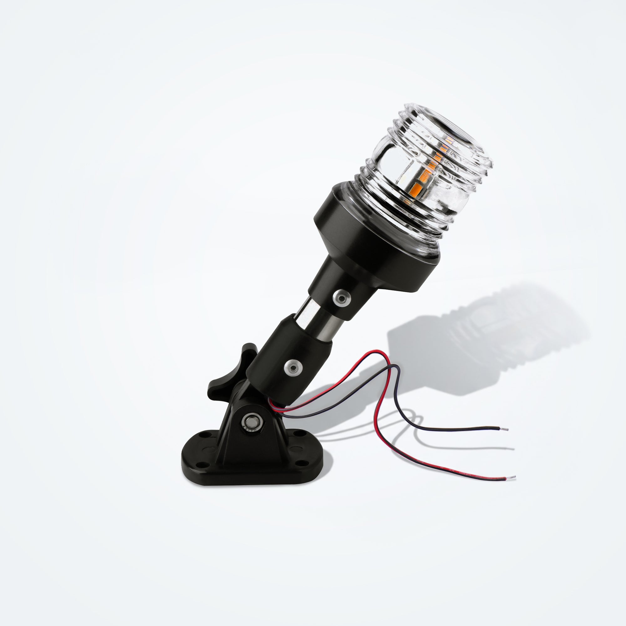 Marinexplore 6-inch black stainless steel boat anchor light with a clear ribbed lens glowing warm white, mounted on a folding black base with red and black wire leads, photographed at an angle on a light gray studio backdrop.