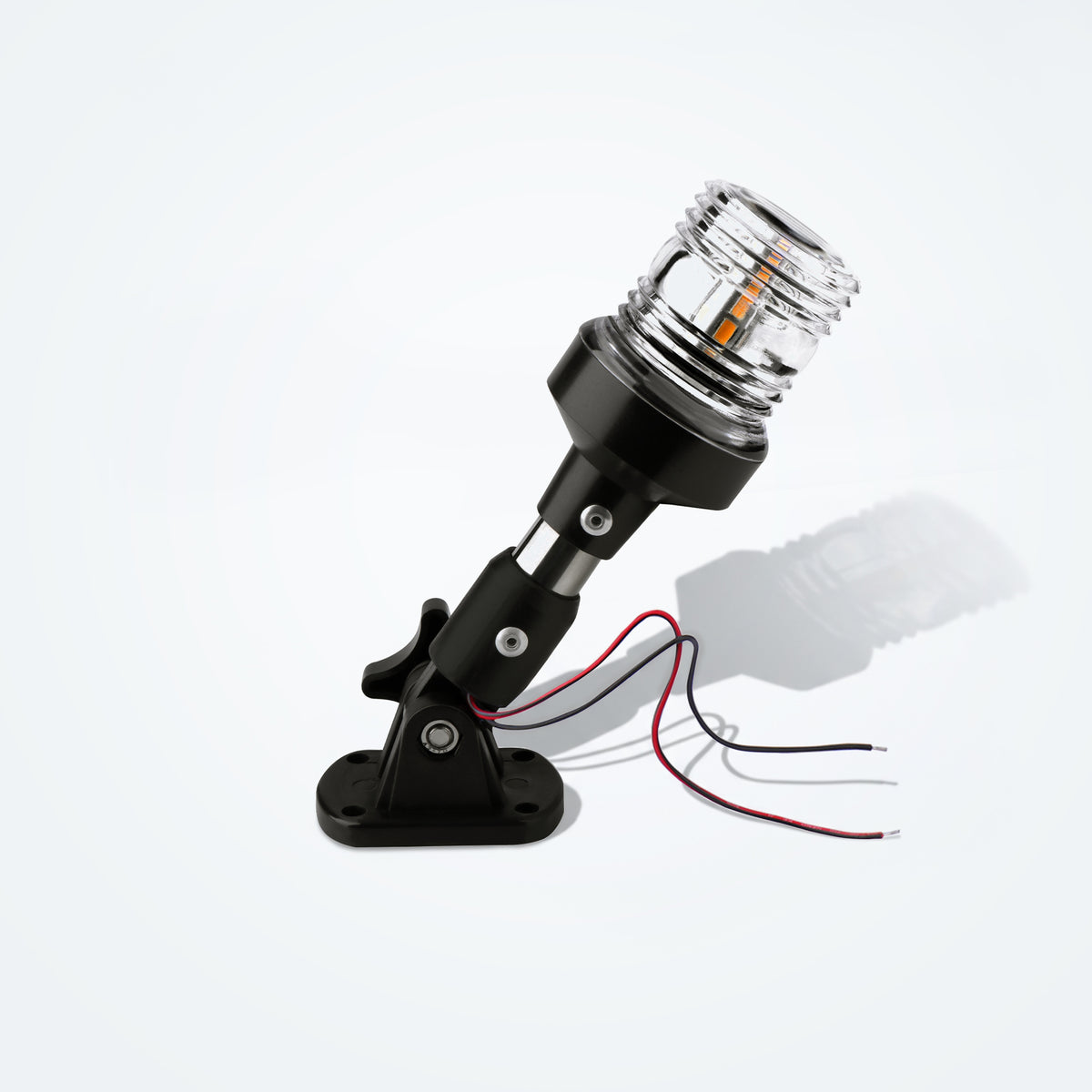 Marinexplore 6-inch black stainless steel boat anchor light with a clear ribbed lens glowing warm white, mounted on a folding black base with red and black wire leads, photographed at an angle on a light gray studio backdrop.