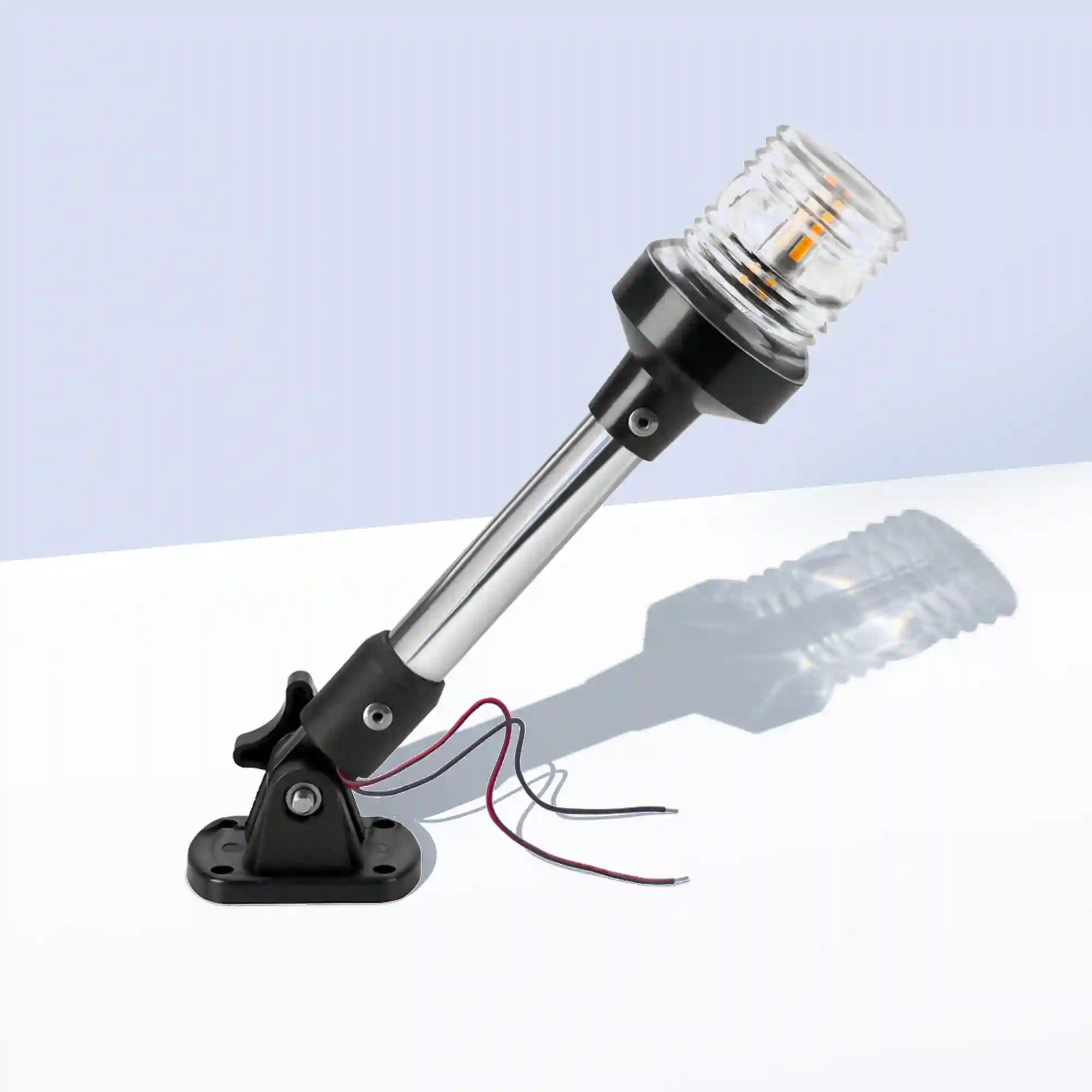 Marinexplore 9-inch anchor light with a polished chrome pole and clear ribbed lens glowing warm white, mounted on a black folding base with wire leads, photographed at an angle on a light gray studio backdrop.