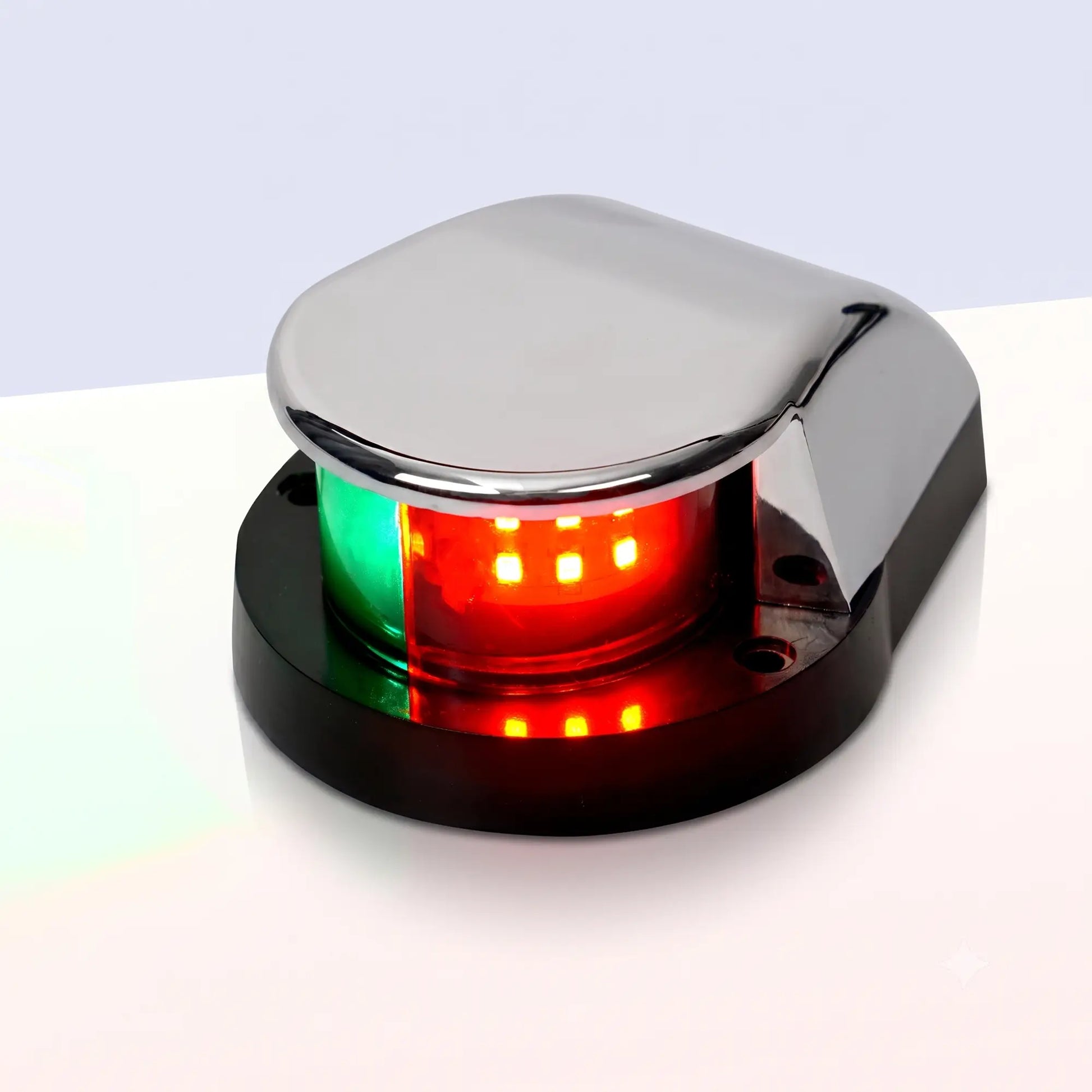 Marinexplore silver ABS boat bow navigation light with a teardrop-shaped dome housing and two mounting screw holes on the black base, photographed at a three-quarter angle showing the illuminated green and red bicolor lens against a light gray studio backdrop.