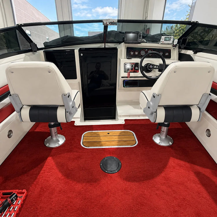 Customer photo of two white and black captain's seats mounted on pedestals in a red boat cockpit.