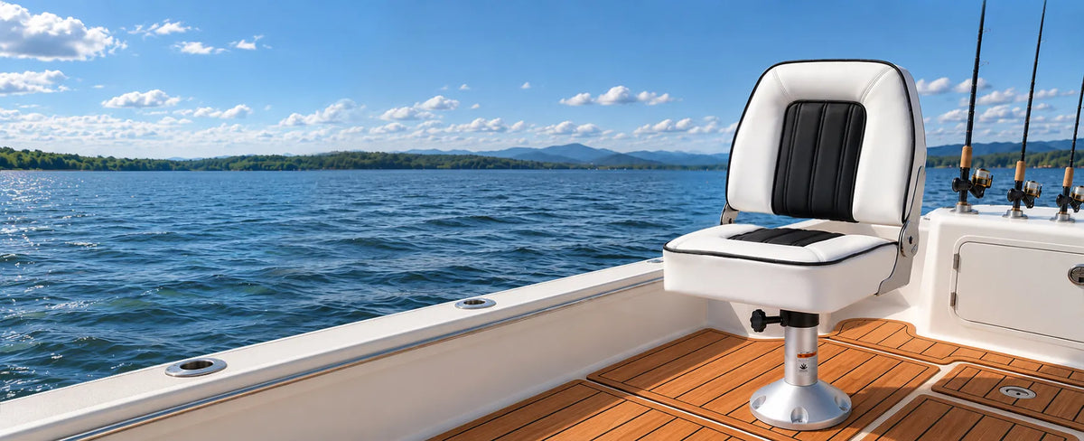 Marinexplore white and black fold-down boat seat mounted on a pedestal beside a blue lake.
