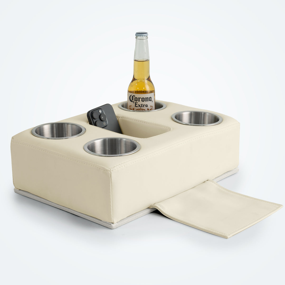 Marinexplore beige PU leather pontoon cup holder with four stainless steel cup inserts, a center storage slot holding a black smartphone, a Corona beer bottle in one cup, and the bottom anchor strap pulled out, photographed from a front angle on a light gray surface.