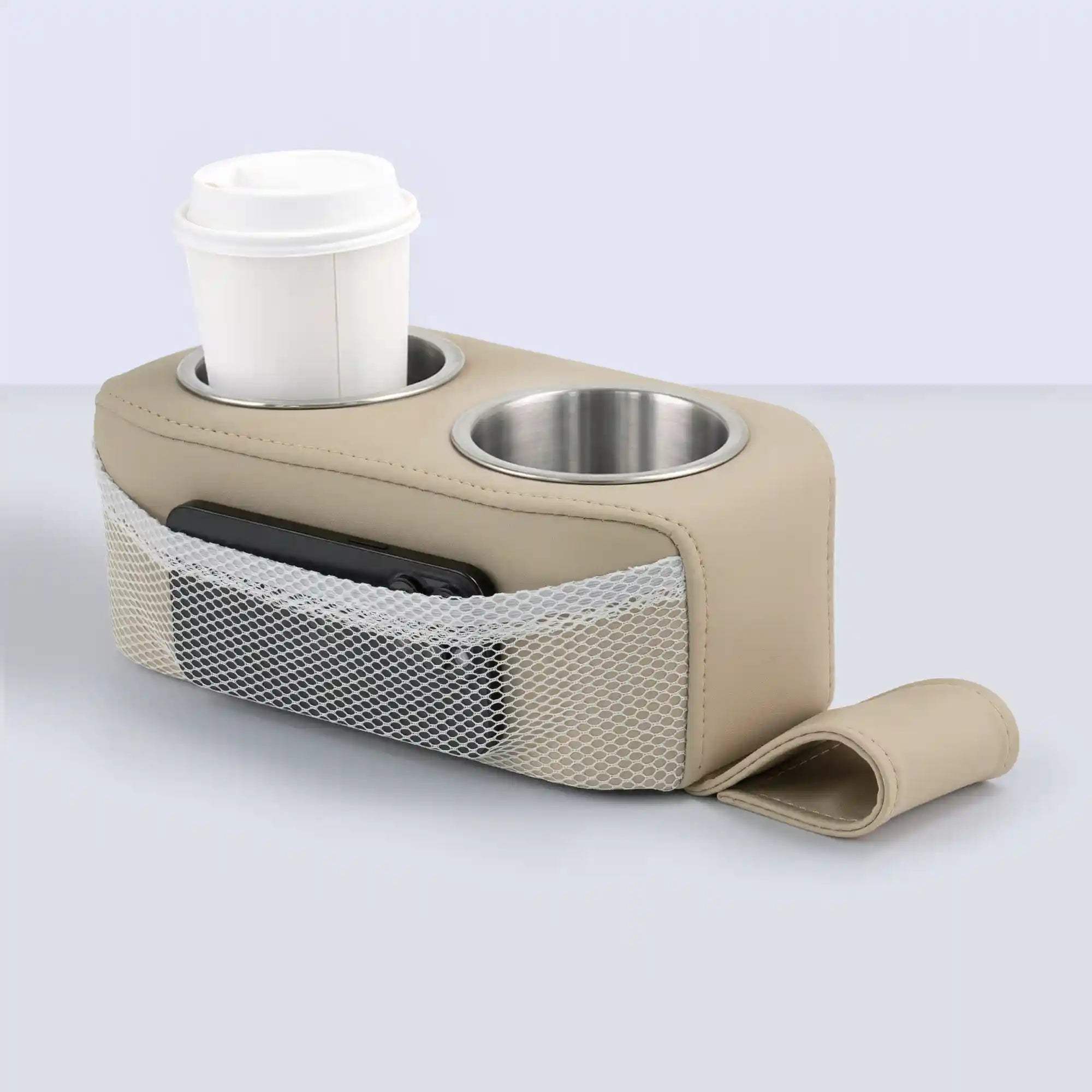 Marinexplore khaki PU leather pontoon seat cup holder with dual stainless steel cup inserts, a white lidded coffee cup placed in the left holder, a black phone visible through the side white mesh storage pocket, and the anchor strap laid flat in front on a gray surface.
