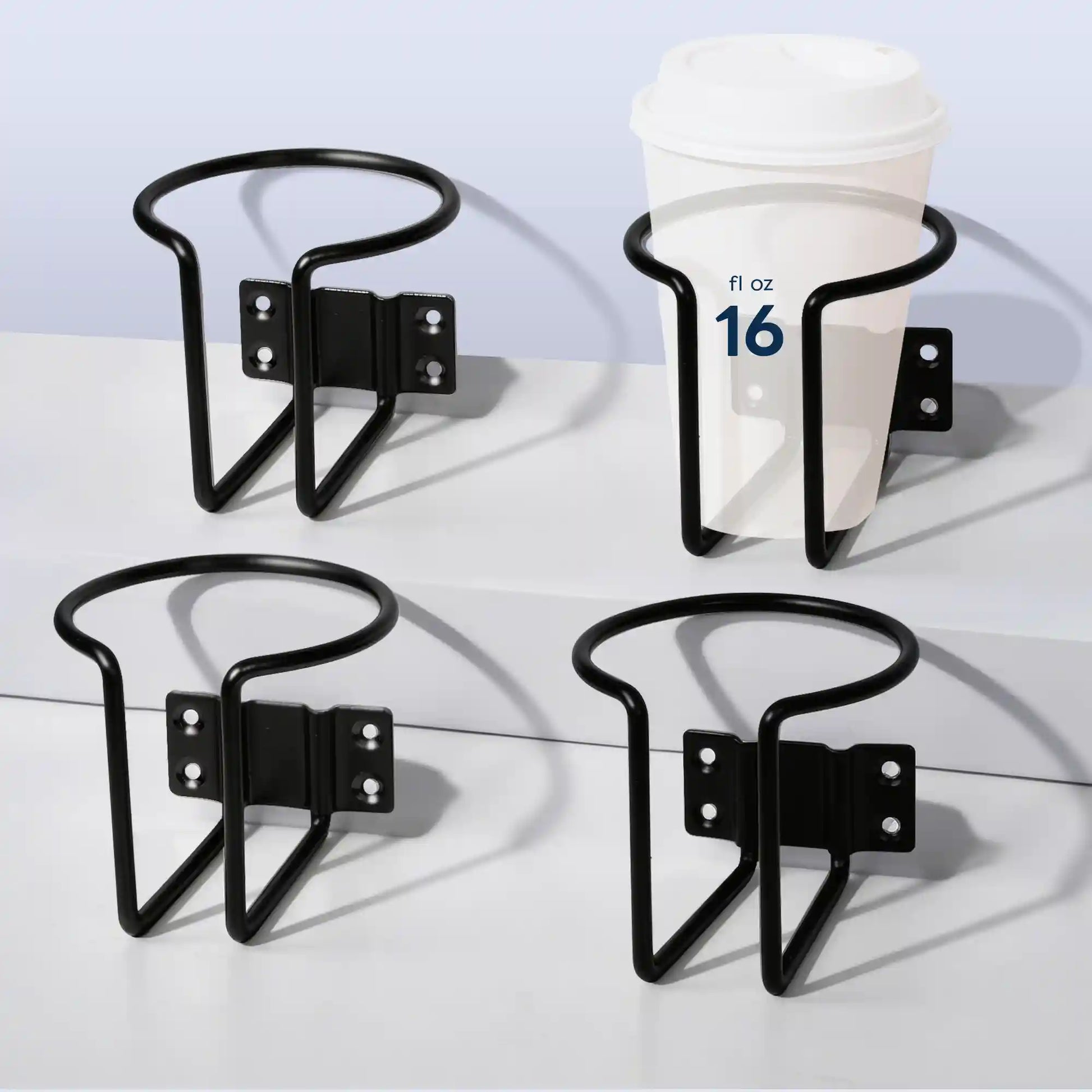 Four angles of Marinexplore black wall-mounted boat cup holders displayed on a white surface, with one holder securing a 16 fl oz white lidded takeaway coffee cup to demonstrate holding capacity and ring fit.