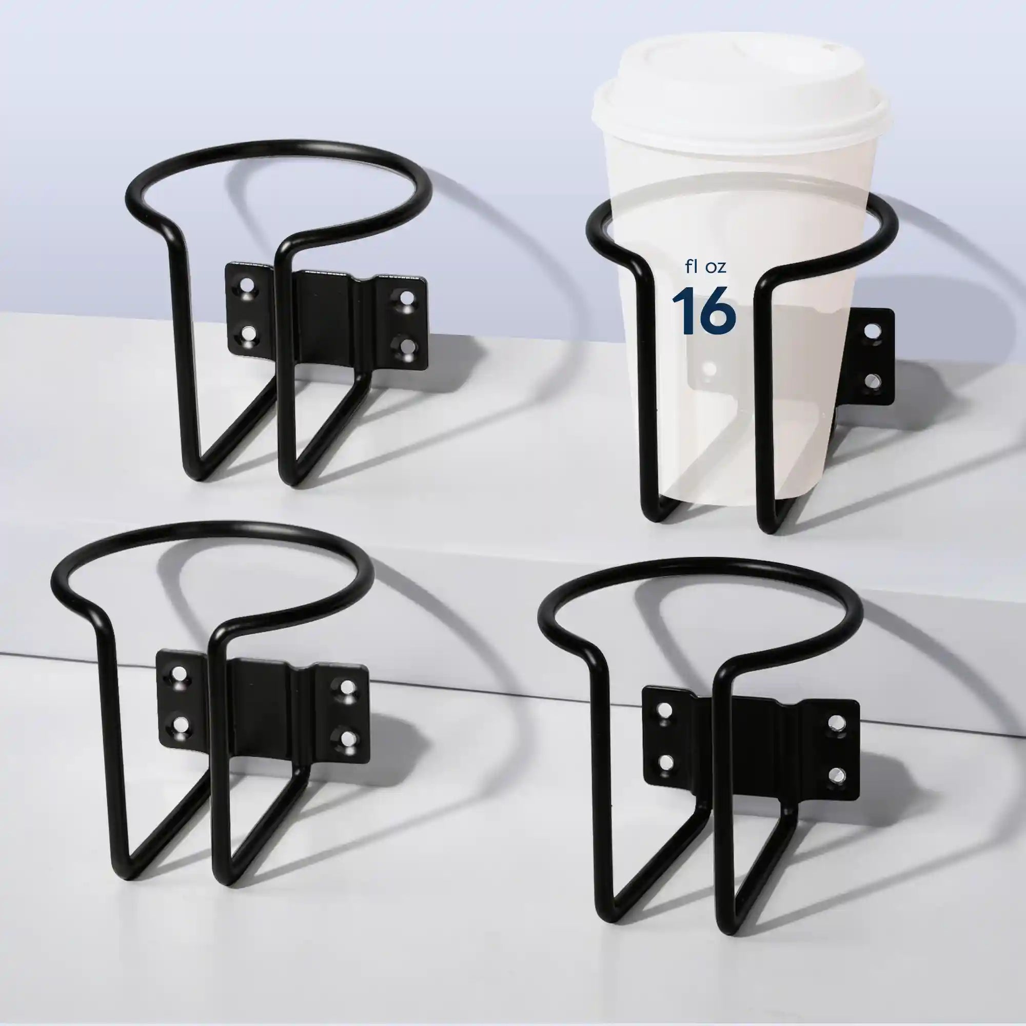 Four angles of Marinexplore black wall-mounted boat cup holders displayed on a white surface, with one holder securing a 16 fl oz white lidded takeaway coffee cup to demonstrate holding capacity and ring fit.