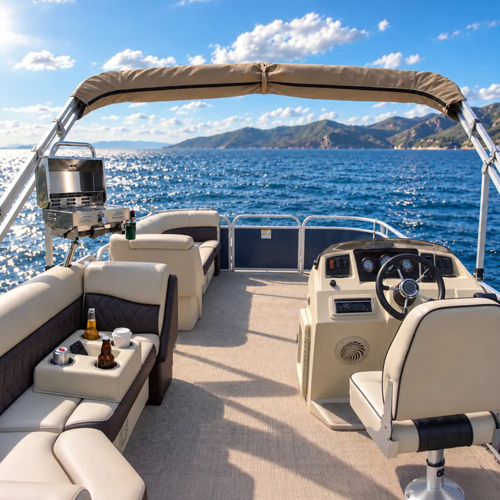 Stainless steel boat grill and pontoon cup holders beside comfortable seating on a pontoon boat cruising across the ocean on a sunny day.
